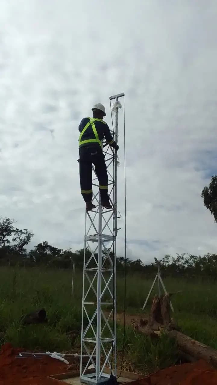 Técnico instalando câmera em torre de monitoramento